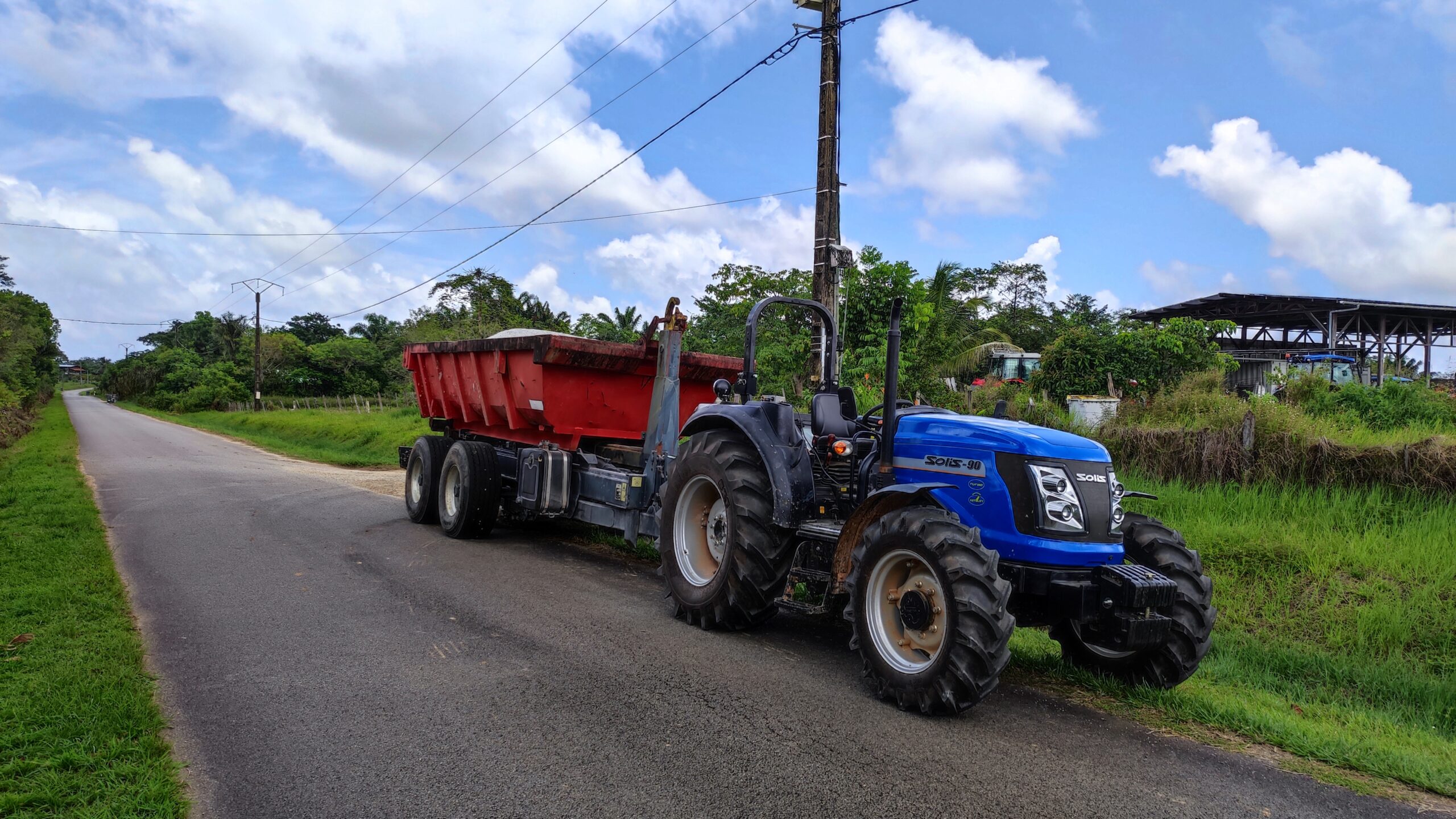 Photo d’un tracteur Solis 90 chevaux accompagné d’une remorque